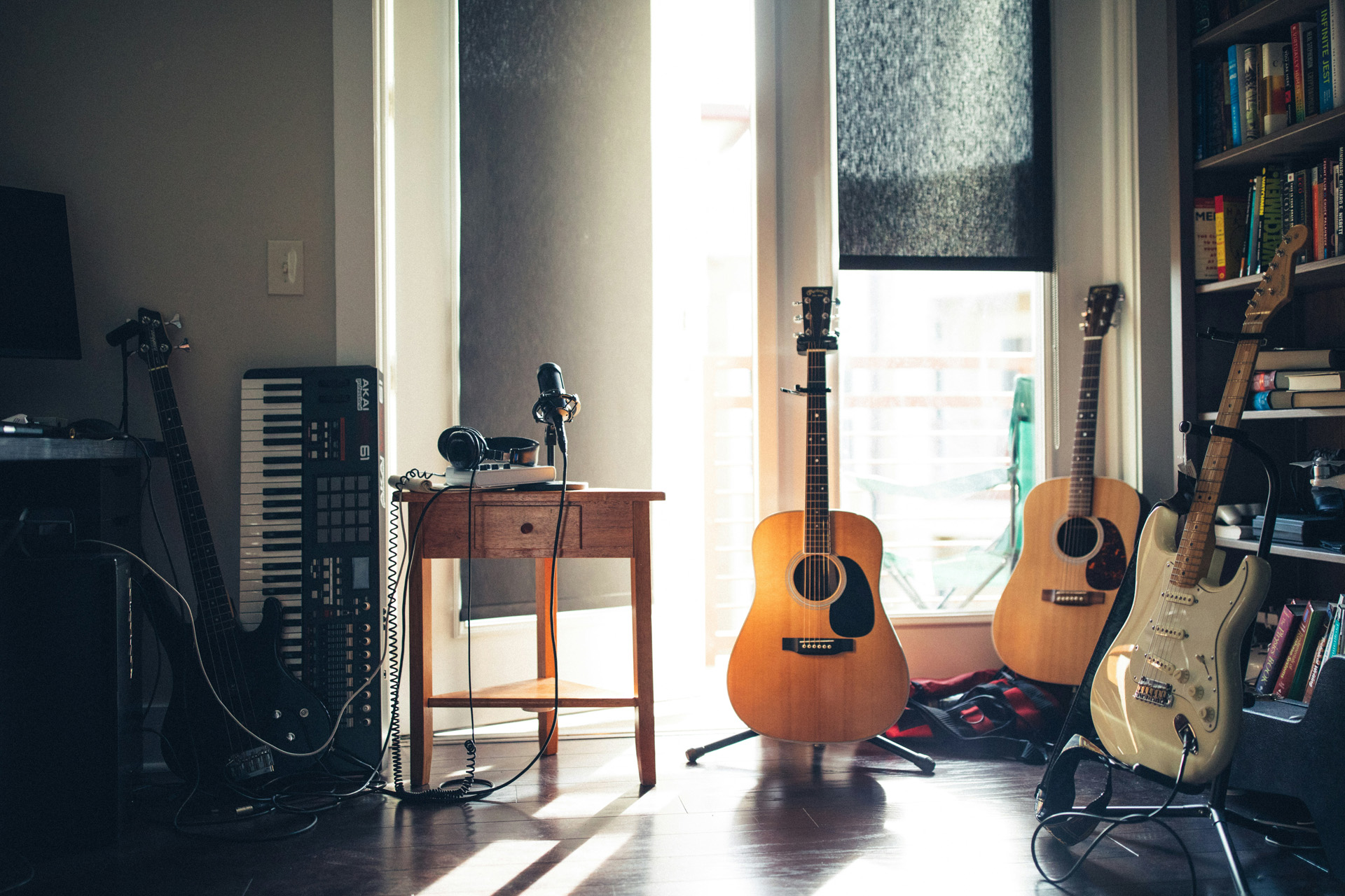 Guitars and a keyboard sit next to an amplifier on the floor.